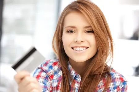 helles Bild, Frau mit EC-Karte, Person mit Kreditkarte, glücklich über die Zahlungsmethode am Kartenterminal